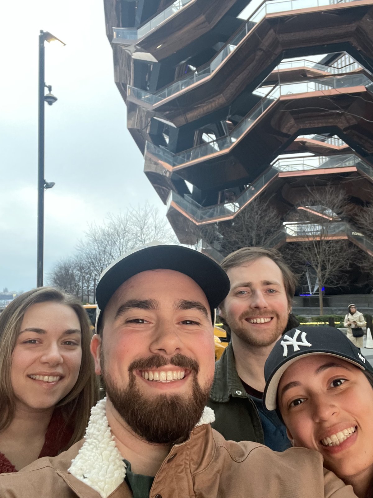 Four friends taking a selfie in front of the Vessel in New York