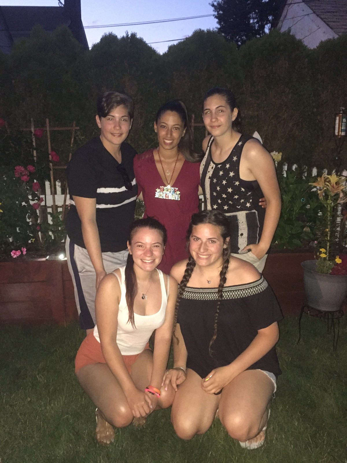 Four friends together in a garden at dusk