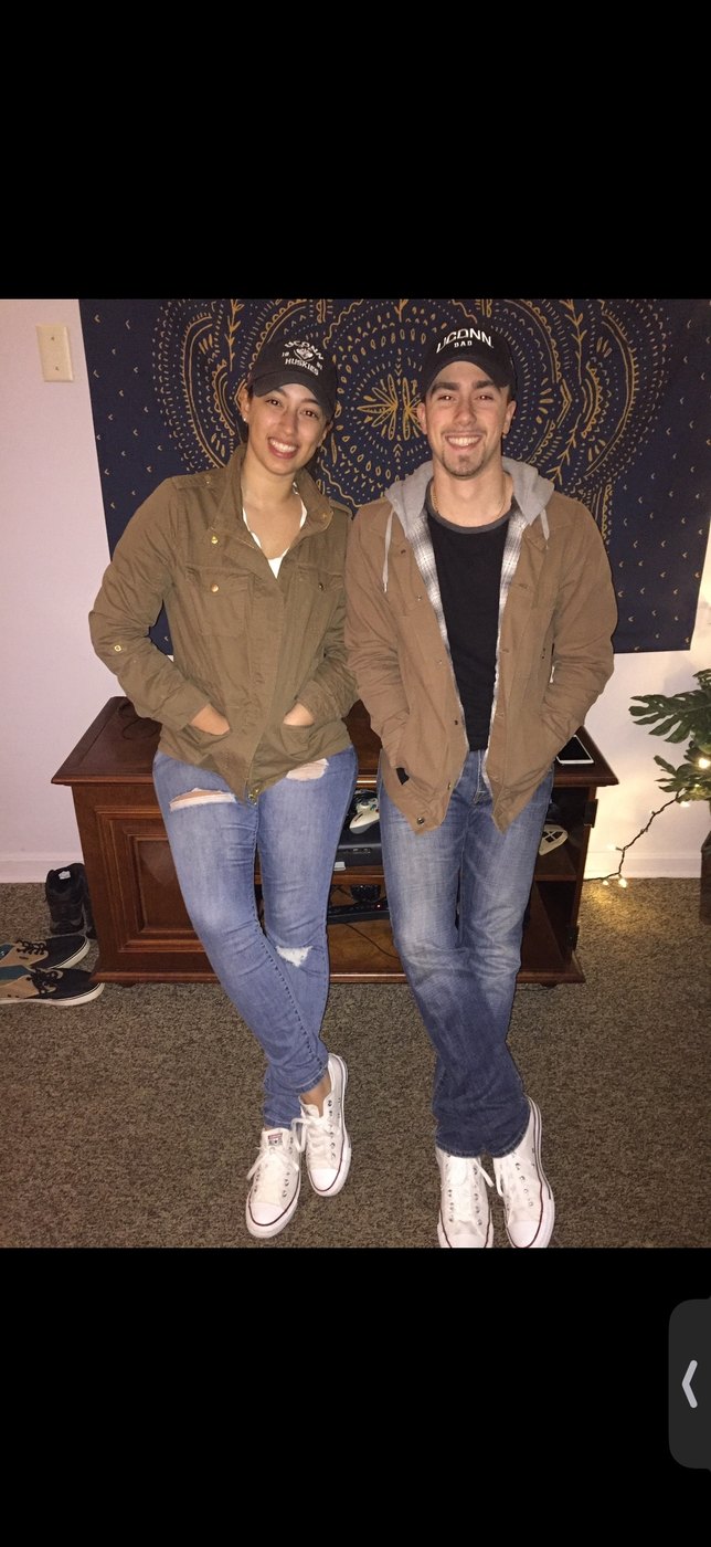 Austin and Bianca in matching tan jackets and caps at home
